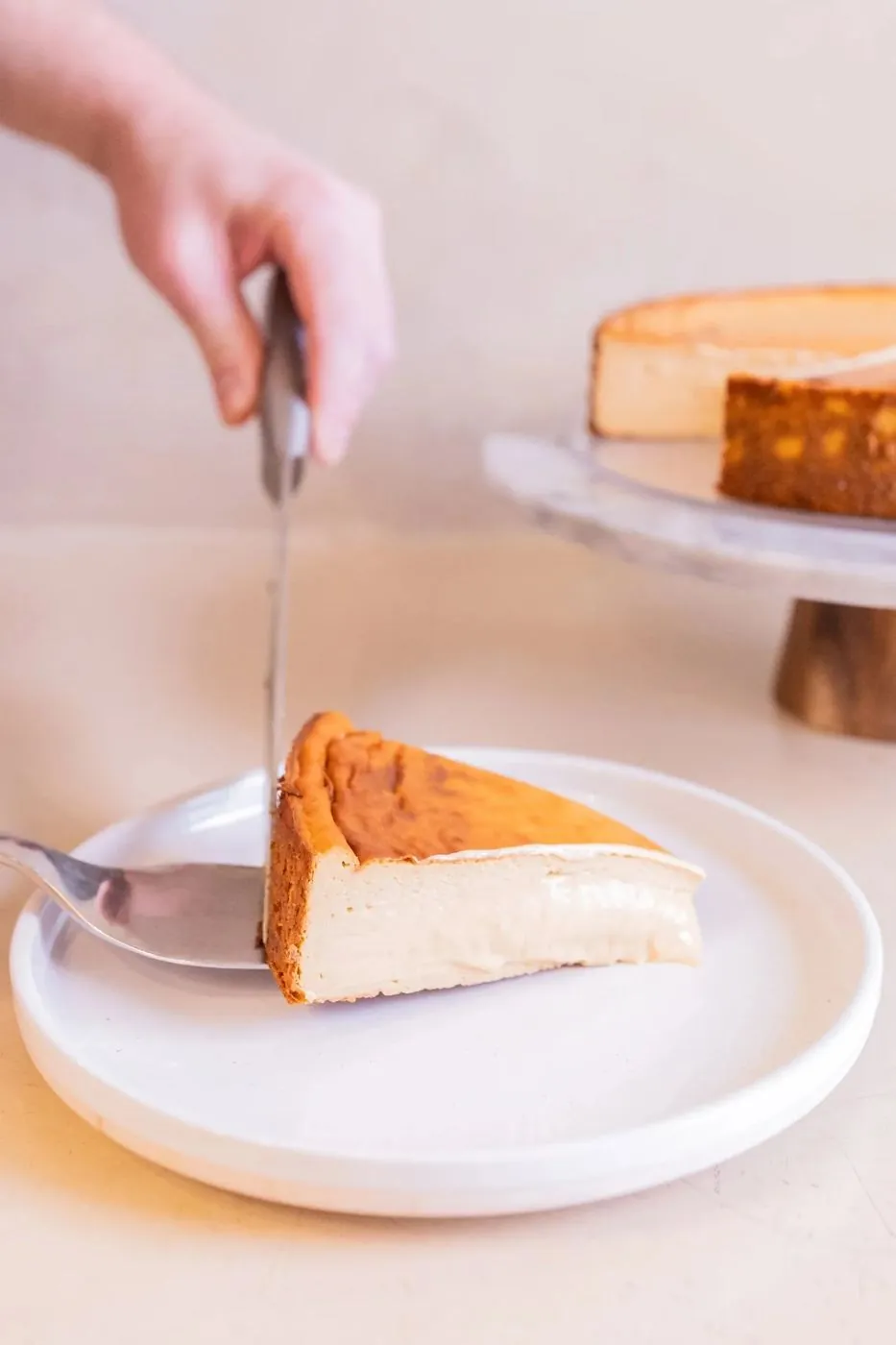 Porción de cheesecake recién cortada en un plato, con el centro cremoso