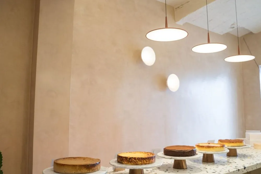Interior de la tienda de CHICA en Granollers, con las cheesecakes del día sobre el mostrador de terrazo